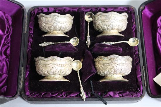 A cased set of four Victorian embossed silver salts and matching spoons, Sibray, Hall & Co, Sheffield, 1882, 8.4 oz.